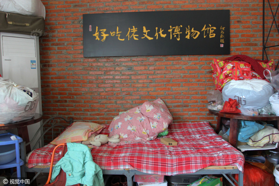 售楼部大门的大厅左右两侧，分别住了两家人，他们用简易布料、板子围起一个帐篷式的空间，里面放了床、厨具等生活用品。往里走有一间二三十平方米的会议室也住了一家人。