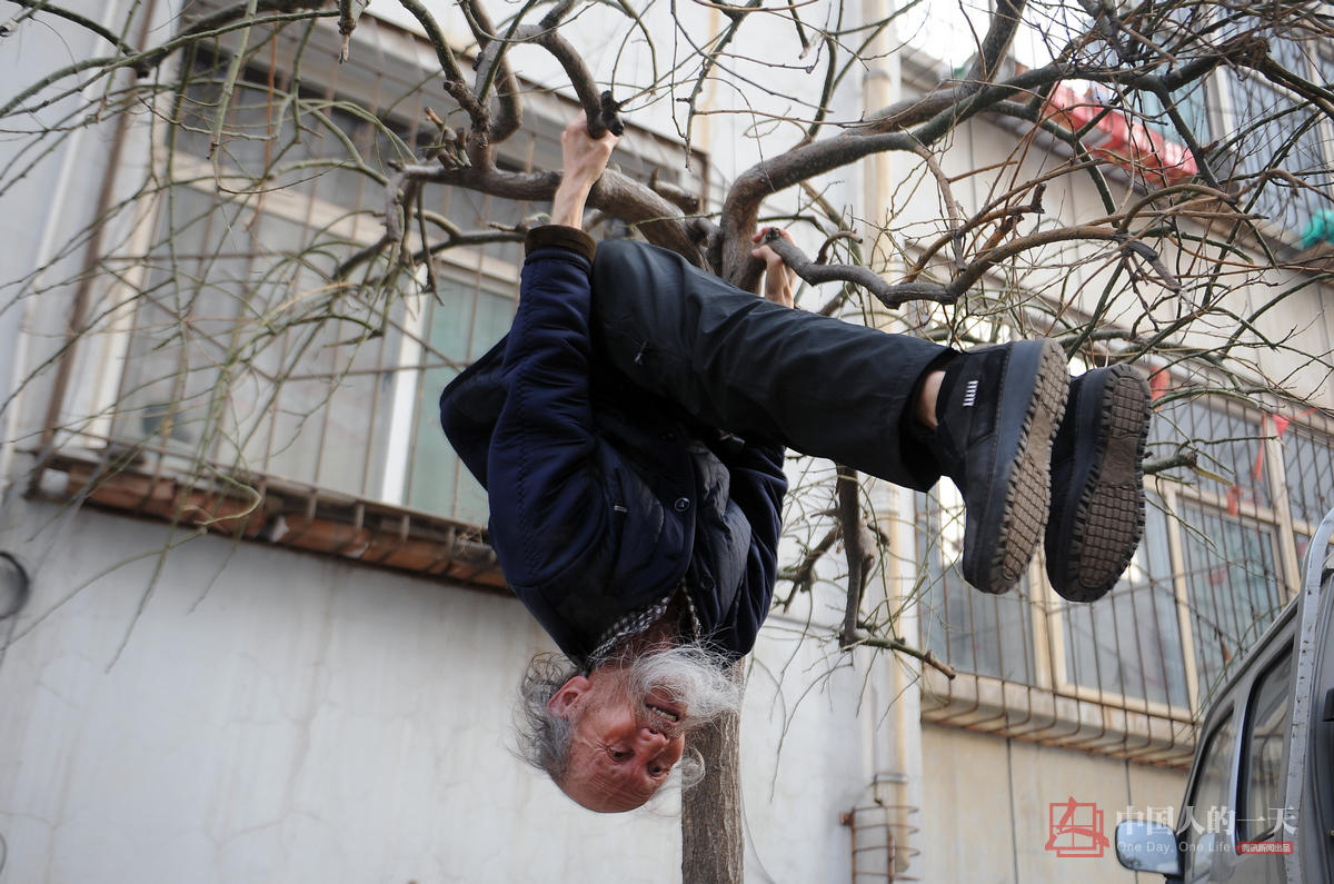 　　刘富中在家门口的小树叉上练习悬挂，他每天都要树叉上倒挂十几分钟。