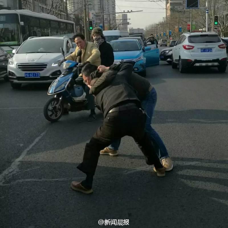 　　你一个过肩摔，我一个横扫腿，接着扭打在一起，互相缠斗难分伯仲……这幕刺激的武打动作场景，昨天早高峰时在上海安波路营口路上演，而冲突竟源于“路怒”！目击者肖先生告诉记者，昨天上午8点不到，他经过安波路、营口路路口时，看看两名男子扭打在一起，场面十分激烈。“我顺势拿出手机拍了几张照片，旁边也有行人上去劝架。”肖先生说，在两名男子的身旁，一横一竖停着两辆轿车，“我想可能是两个人开车有点摩擦引起的‘路怒’吧。”