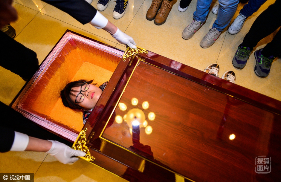 并不是让你真的去“鬼门关”走一遭，但哀乐响起，穿上寿衣、吃一顿离别饭、留下一封遗书再安睡在棺材，有关死亡的种种仪式逼真地在体验者身上过一遍，你或许那么一瞬间会有死去活来的恍惚。3月25日，天津市华明天裕殡仪服务中心举办“死亡体验”活动，来自天津高校的志愿者及自愿报名的体验者走进这里的人生告别厅，参与模拟的遗体告别仪式，并亲身躺入棺材中，在黑暗中独自进行对生与死的沉思。