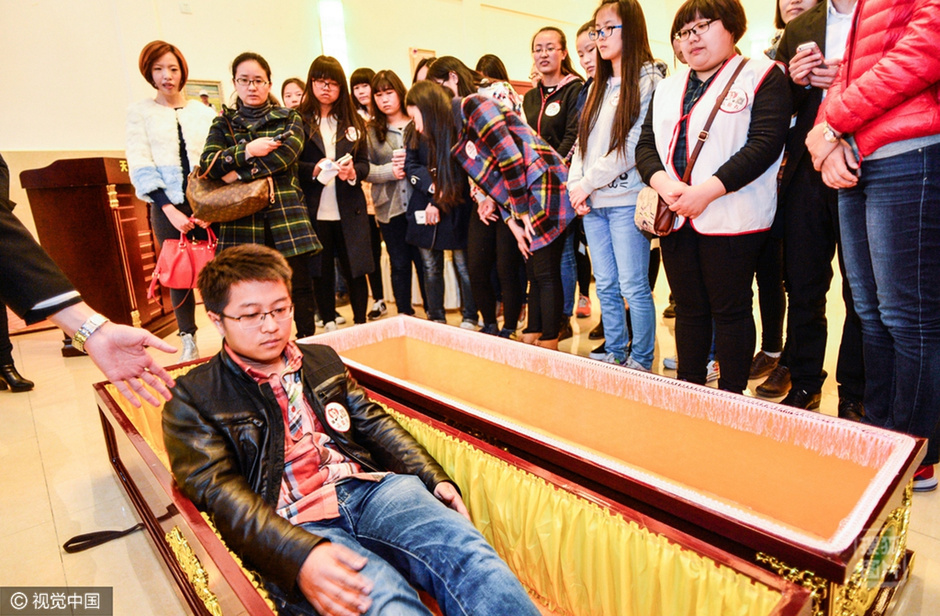 此后，他们将在黑暗封闭的棺材中躺10分钟，时间变得虚无，从而使其以局外人的角度重新审视、思考生活。负责人解释说，这一过程是要帮助其面对问题，在困境中发现快乐。“棺柩疗法”的概念是几年前一个乌克兰棺木制造商提出的，大多数接受治疗的人表示，治疗后他们的心态变得更加积极。图为体验者躺入棺材中，参与“死亡”体验。