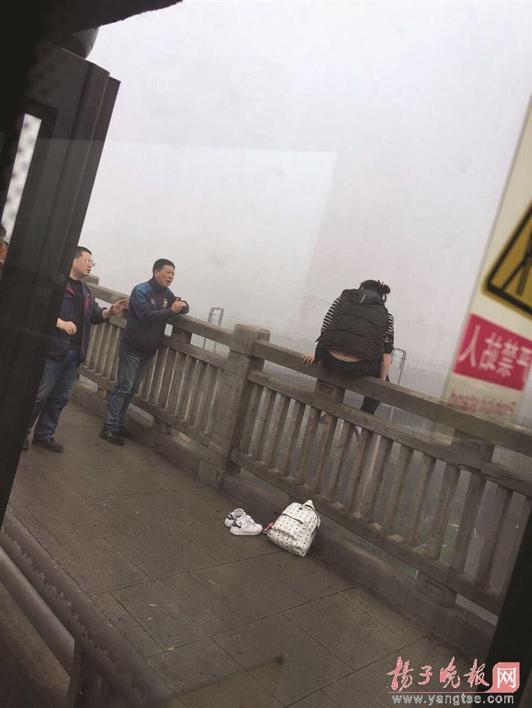 2号下午2点多，在南京长江大桥南引桥处，一辆路过的572路公交车突然停了下来，原来司机发现一名年轻女子正坐在大桥的护栏上，背对着大桥路面，随时都有坠桥的可能。司机急忙打开公交车车门，下车对欲轻生的女子进行劝说。此时，另一辆D2路公交车也驶至这一位置，看到这一场景后，该车司机也停下车，悄悄打开车门，趁女子不注意走至她身后，突然出手将她抱下。