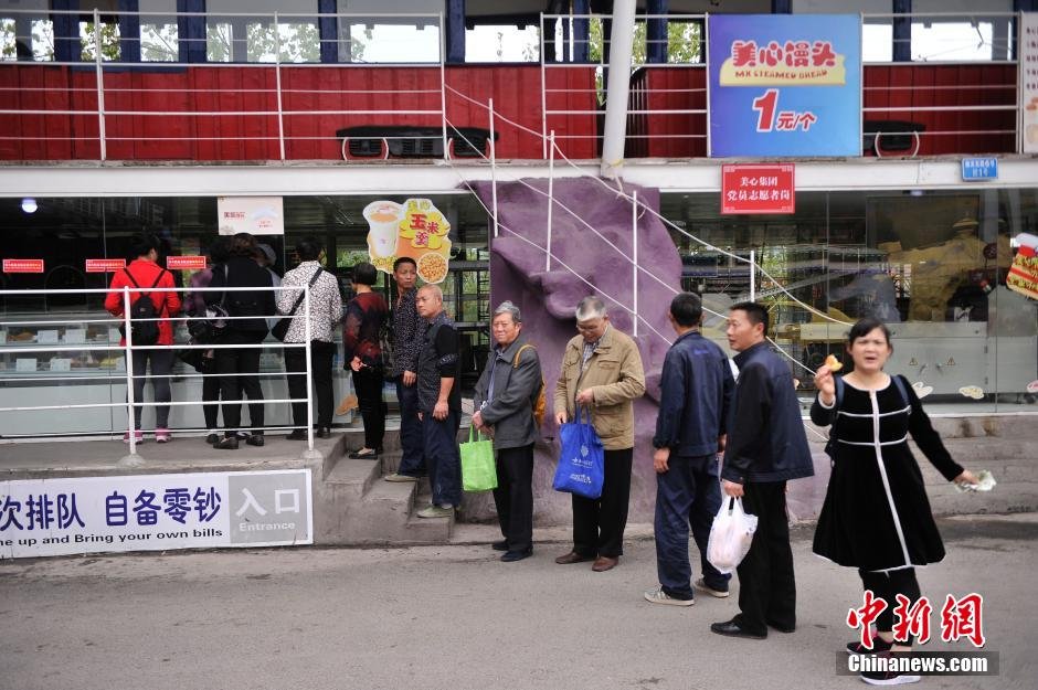 　　重庆洋人街内的馒头店铺处顾客排着长队等待购买大馒头。