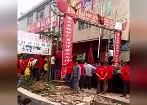 　　其中一方迎亲队伍堵在彩门前，与另一迎亲队伍争论。