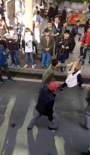 　　图为现场，男子和老人对打，捉住了老人的脖子。