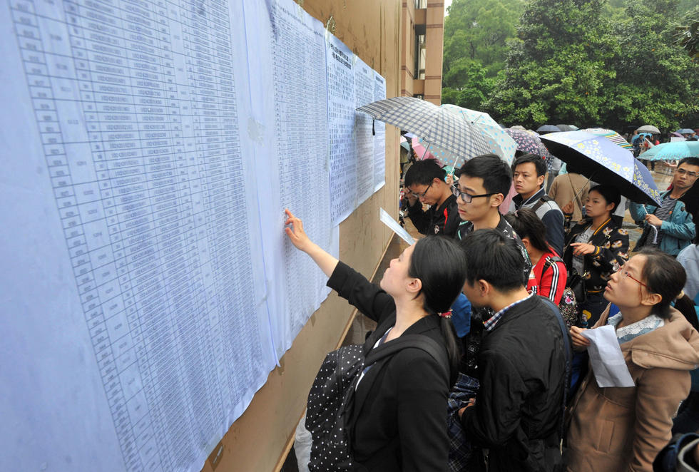 　　4月23日，在华中科技大学考点，考生冒雨参加湖北省公务员考试笔试，雨中伞花蔚为壮观。图为考生查看考场位置分布信息。