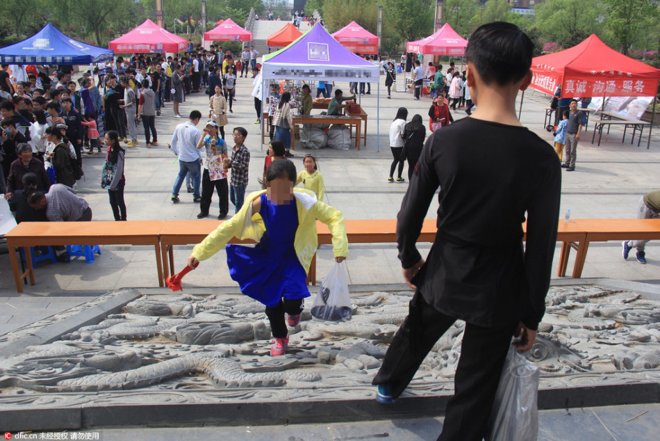 　　2016年5月1日，江苏连云港，一位小朋友在连云港市赣榆区生态公园景区内雕塑上随意攀爬。