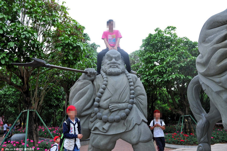 　　2016年4月29日，广西南宁市，在青秀山风景区内一处“唐僧师徒”雕塑，一些游人为了“零距离”与这些雕塑合影，随意的攀爬在雕塑上面拍照，即便有醒目的“请勿攀爬”提示语，这些游客依然我行我素。