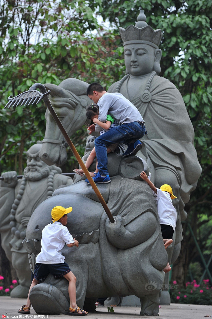 　　2016年4月29日，广西南宁市，在青秀山风景区内一处“唐僧师徒”雕塑，一些游人为了“零距离”与这些雕塑合影，随意的攀爬在雕塑上面拍照，即便有醒目的“请勿攀爬”提示语，这些游客依然我行我素。