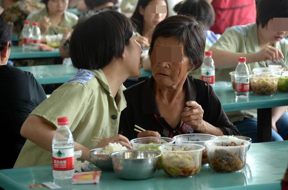 吃团圆饭时，一名服刑人员和母亲说悄悄话。