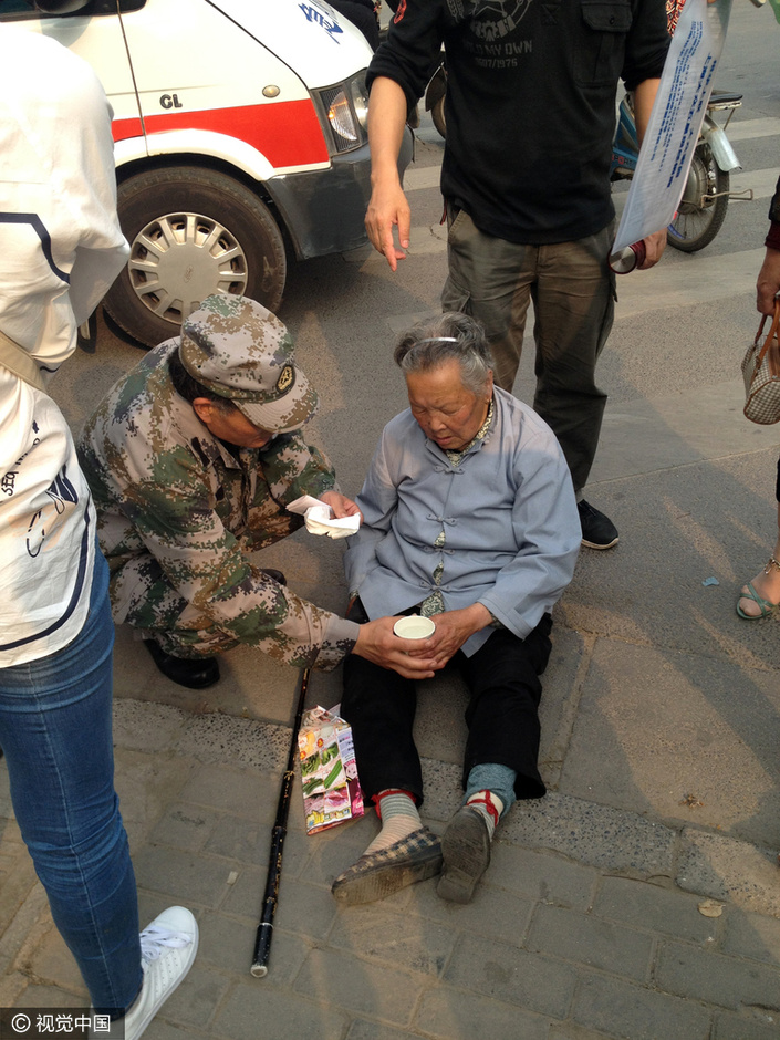 一名中年男子向120急救人员描述现场情况，中原区林山寨办事处巡防队员疏导交通的同时，还给老人端来一杯茶水解暑。