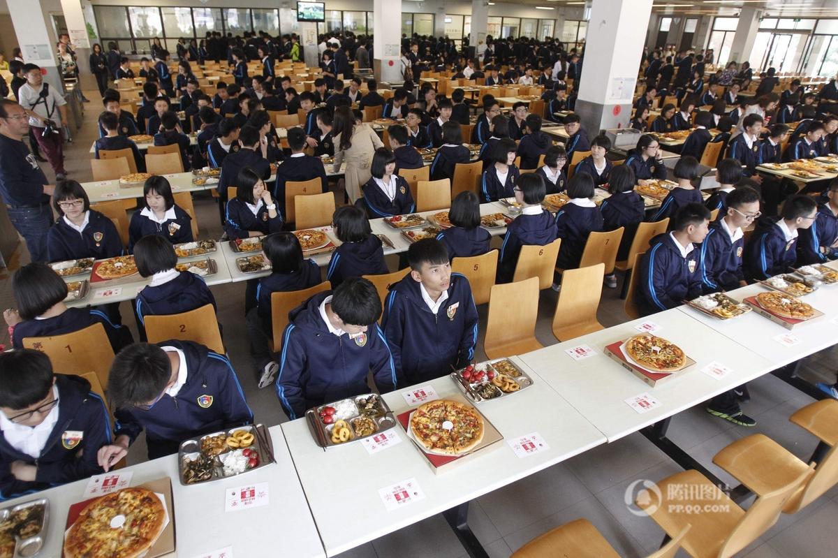 　　河南省郑州市一中学食堂内，150多张披萨被沿桌摆满。