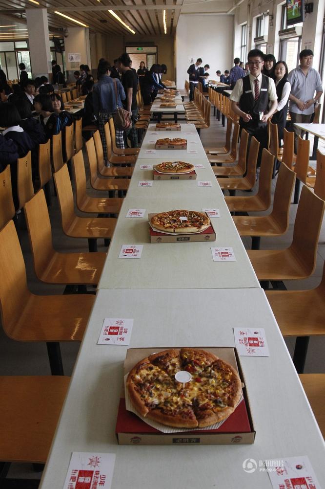 　　河南省郑州市一中学食堂内，150多张披萨被沿桌摆满，600多名初三学生共进“披萨大餐”。