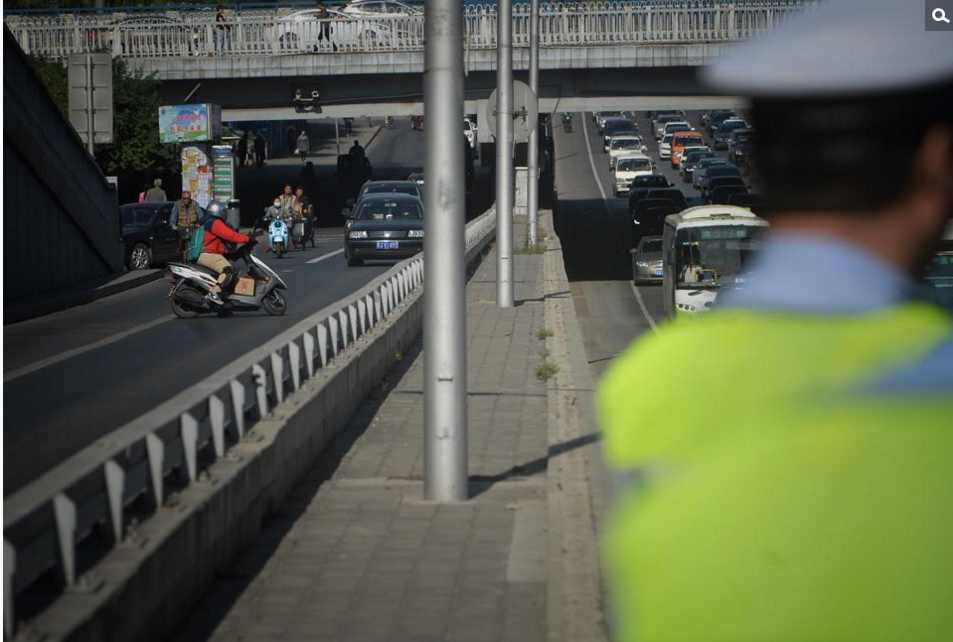 图为一辆摩托车发现交警后调头躲避。