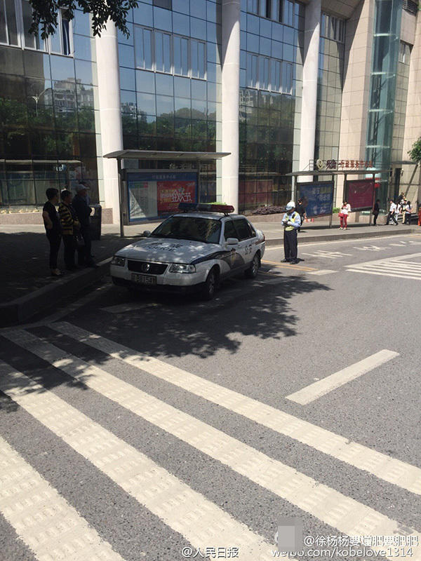 　　图为交警在对违停的警车开罚单。