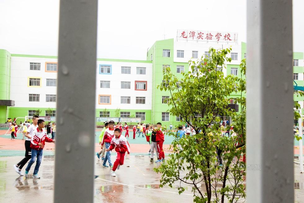 由于采访时间正值午休时间，记者没能与校方取得联系。更多相关的情况，还有待校方进一步证实和确认。截至5月27日，这些家长已在此处排队4天4夜。图为龙潭实验学校校园内，孩子们在课间活动。
