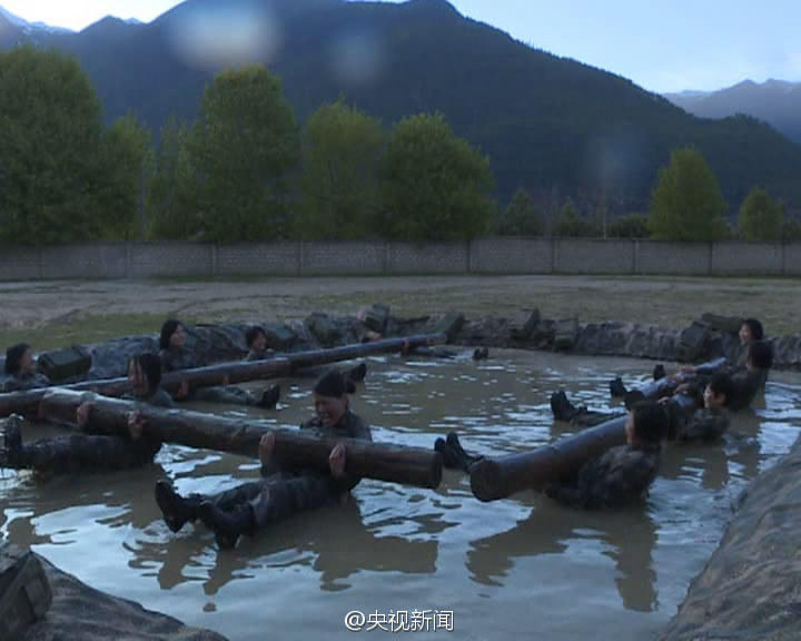 女兵水中抱60余斤圆木仰卧起坐。
