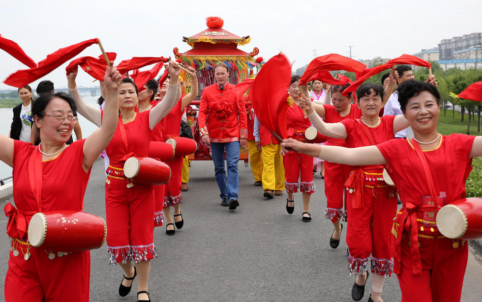 2016年5月28日，湖北省襄阳市，由秧歌队开道，洋女婿带队，八抬大轿抬着新娘在襄阳河堤上经过，引来各种“围观”。吸引人眼球的，不仅因为这是场原汁原味的中式婚礼，采用传统的八抬大轿，更因为婚礼的男主角是位“洋女婿”——来自德国的男士Holger Thoben。