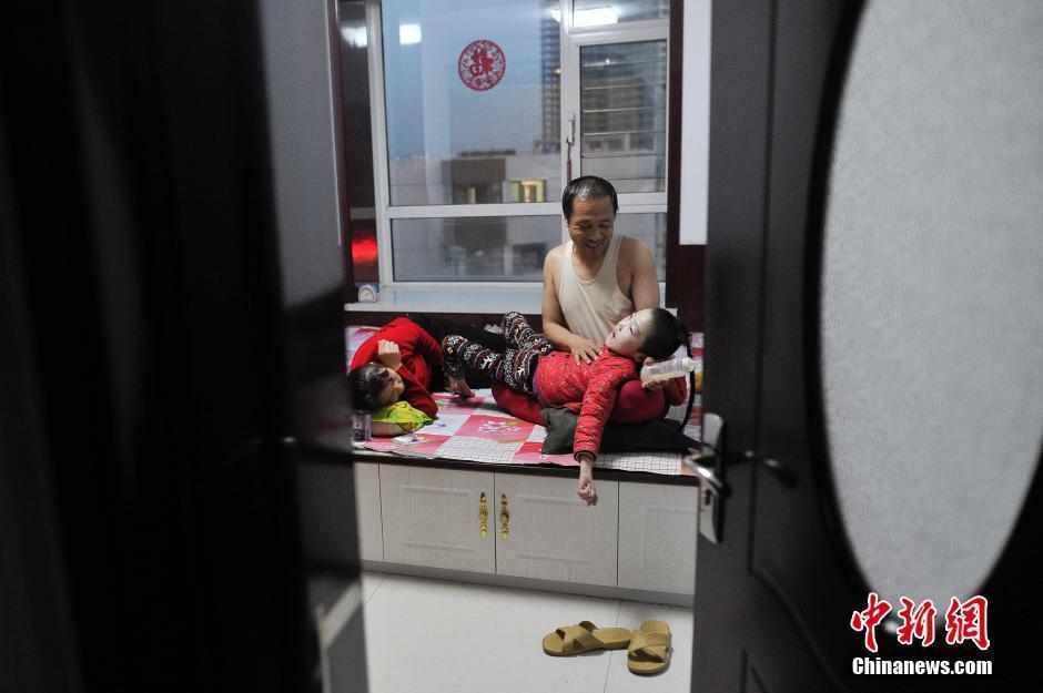 　　“一顿饭喂下来得两个小时，每天花在三顿饭的时间就是六个多小时。”赵玉春说，长期以来，每次饭熟后首先要给丽坤喂食，常吃冷饭的两口子都患上慢性胃炎。长期抱着孩子低头喂食的坐姿，也让他们落下不同程度的颈椎和腰椎病。图为5月29日，赵玉春与生病的妻子李焕梅在家中陪伴脑瘫女儿赵丽坤。