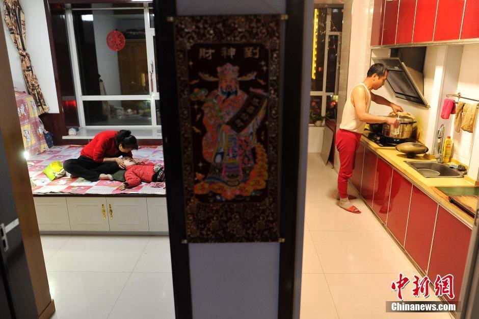 　　图为5月29日，妻子李焕梅在家中陪伴脑瘫女儿赵丽坤，丈夫赵玉春为她们张罗晚饭。