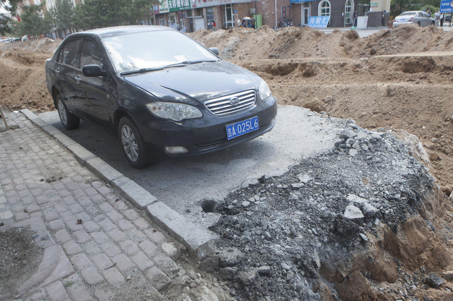 　　5月31日，长春市世荣路路边上的一辆轿车，其周边整条路的柏油及路基都被挖开，这辆车俨然像是停在了“孤岛”上。
