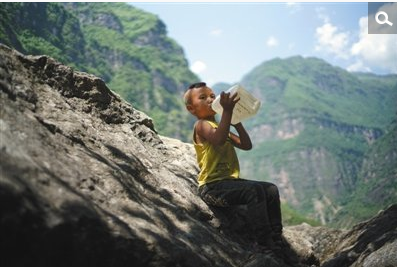 　　村里的房子多用夯土建成，一旁围绕玉米地。家家户户也很少为门上锁，彼此熟悉信任。要串门，村里没有平坦的路。一到雨天，路上泥泞，鞋下沾了湿泥，步伐变重，孩子们会走到带尖的石头旁，把鞋上泥土刮掉。陈木黑，6岁，学前班。陈家第五个孩子，上下学时，父亲会在其腰间系绳子牵引。