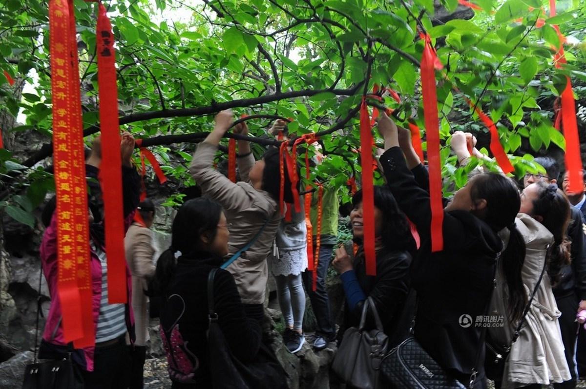 　　5月22日，江苏扬州何园，高考前夕，高考学子及家长到何园通过“读书楼下击鼓明志”、“爬读书楼”、“书写悬挂祈福带”为即将到来的高考带来一份好心情。图为家长在悬挂祈福带。