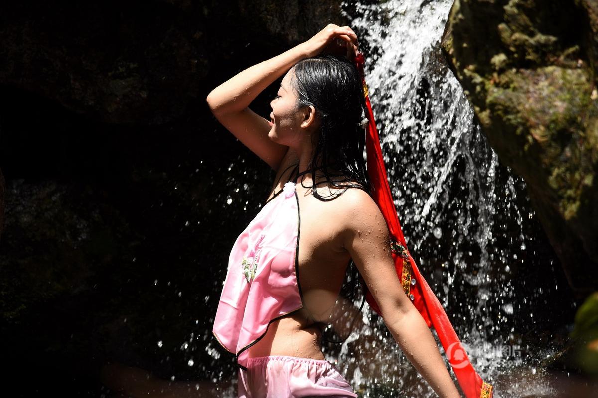 组织上金子山洗泉水浴的姑娘叫阿婧，她平时在广州从事舞蹈老师的工作，是金子山下壮家村寨走出去的姑娘。据她介绍，在壮族传统习俗里，端午节都有洗龙舟水的习俗，认为端午洗龙舟水，能辟邪，不生病，能够延年益寿。小孩洗了祛痱、成年人洗了也会走好运。