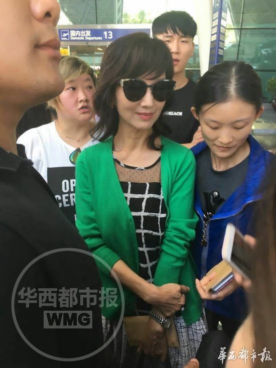 在机场，赵雅芝热情地与粉丝们合影。只见她一身时尚裙装，搭配绿色外套。虽然已经62岁，但精神抖擞，依旧活力四射。袁斌在机场向华西都市报记者透露：赵雅芝一边与成都粉丝热聊，一边与粉丝合影，现场气氛十分亲和而友好。