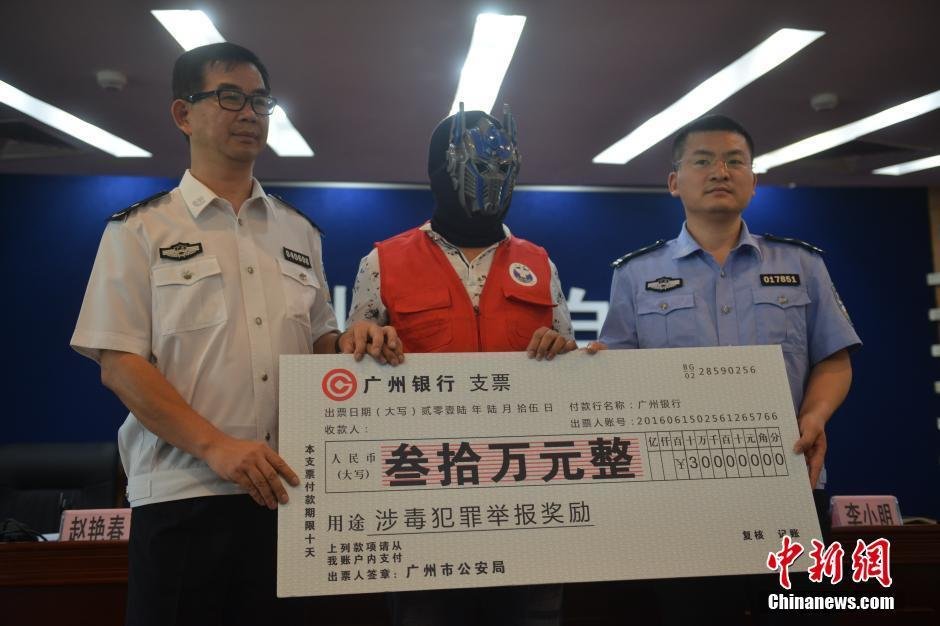 6月15日，向警方提供线索协助破案的快递员戴着“变形金刚”面具，接受了警方现金奖励30万元。