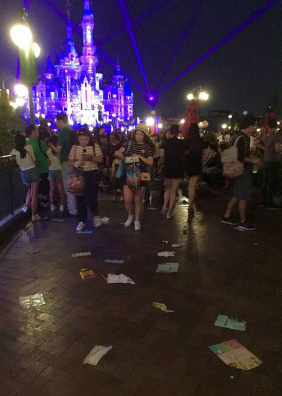 夜光幻影秀结束散场后，米奇大街和奇想花园的花坛周围食物垃圾、塑料袋和纸杯等散落一地。