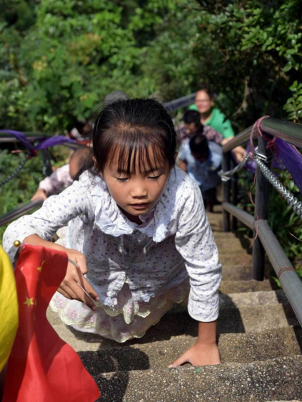 　　到了最后150米梯级时，6名孩子体力已经到了一定的限度了，尤其是女孩。其中一名女孩只能手脚并用，一步一跪地往上爬。即使这样，她的父亲也没有拉她一把，只是在后面默默地看着她，用眼神鼓励自己的女儿。