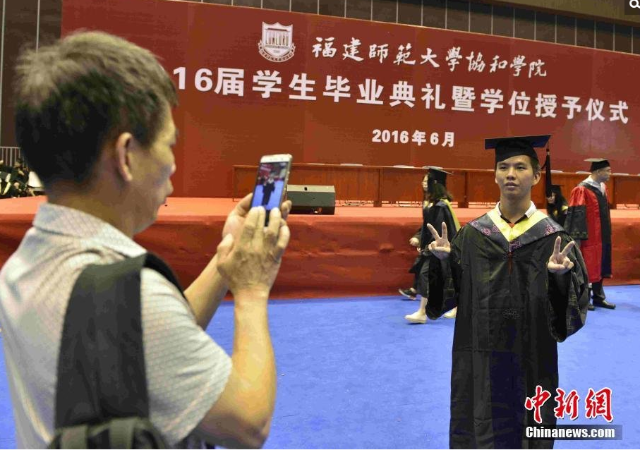 　　6月22日，毕业生家长为儿子张松茂拍摄毕业照。