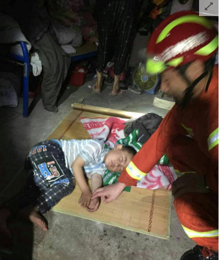 　　23日深夜，扬州消防救援团队已深入阜宁县陈良镇丹平村受灾一线，进行人员搜救工作，协助疏散危房中的老人，儿童们转移。一名受灾儿童在消防人员的安抚下睡着。