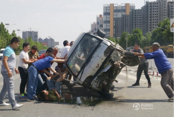 面包车撞护栏侧翻 路人合力推车营救被压司机