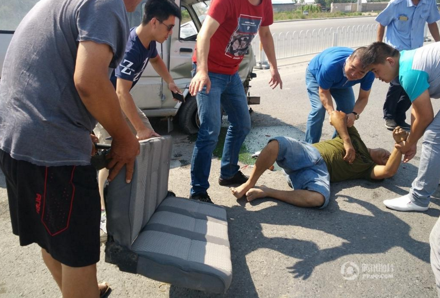 　　为减轻烈日和灼热的地面带来的痛苦，一名爱心路人从破损面包车内取出一把长座椅，路人们将受伤司机小心移至长座椅上，有路人在现场用遮阳帽为受伤司机头部遮挡阳光并鼓励司机克服痛苦等待医护人员的救治。
