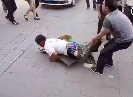 　　7月2日报道，新疆阿勒泰市街头，一名路人当街揭穿一名“残障”假乞丐的伎俩，将他的外裤强行脱掉，竟发现他原来将双脚屈膝藏在内裤中，从而假扮失去双腿的残疾人士。