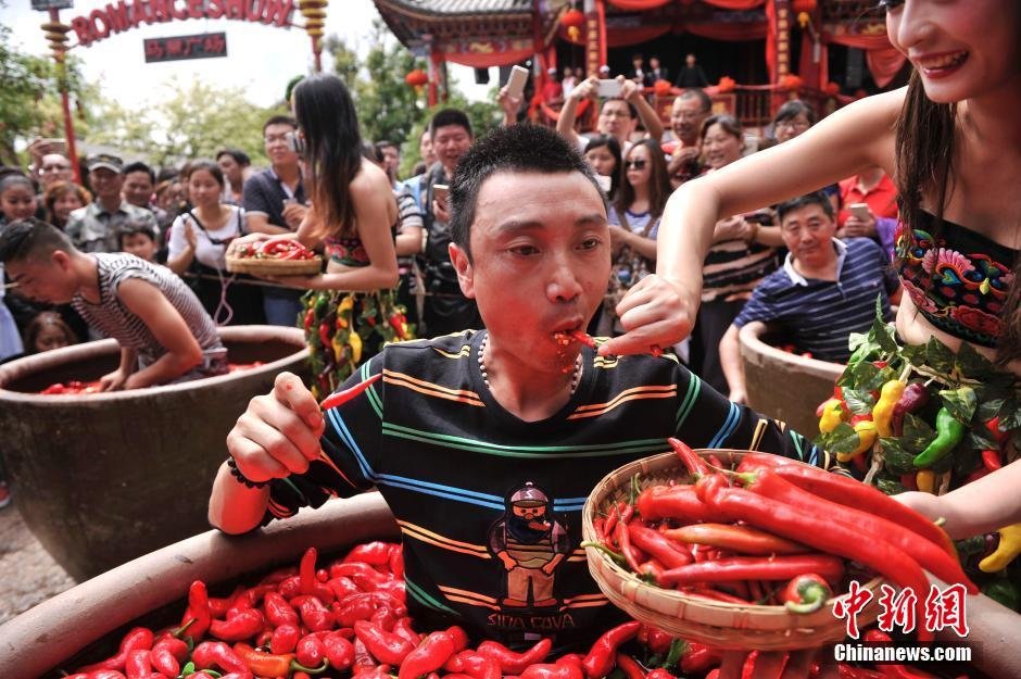 7月2日，云南丽江举办吃辣椒比赛活动，吸引了众多来自全国各地的游客参加。图为一游客正在进行吃辣椒比赛。