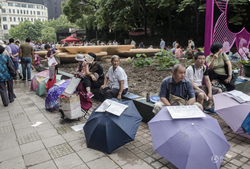 　　2016年7月3日，上海黄浦区人民广场内的相亲角内，聚集了大量为儿女寻觅“另一半”的家长。这些为儿女来此相亲的父母，把一把把雨伞放在路边，贴上写有儿女基本信息和相亲要求的纸条，遇到合适的家长就相互交流，互换联系方式。