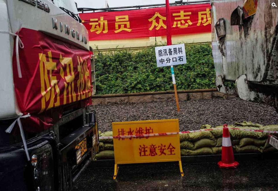 　　龙王庙码头救灾现场。沿着江堤，一路上停放着许多载有沙土的卡车，路旁防汛备用的砂石也都堆放着。