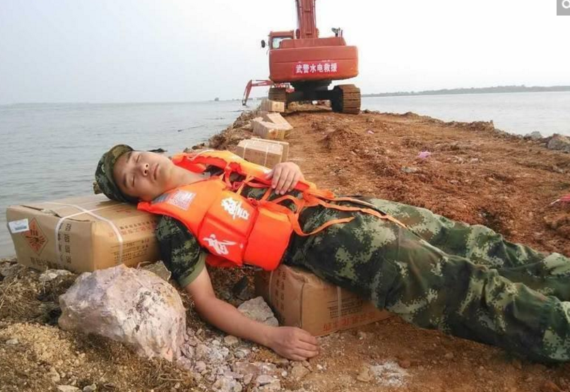 　　在牛山湖大堤连夜作战的武警官兵席地休息。