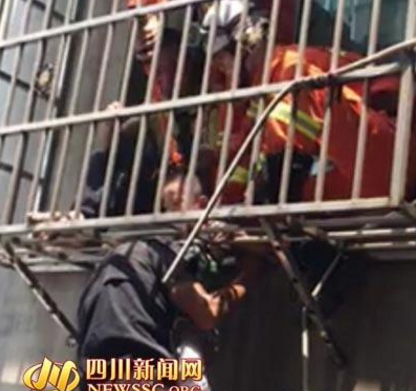 　　此时，在附近执勤巡逻的特警闻讯赶来，也加入救援行动。但由于防护窗太紧，始终无法将小孩取出。眼看着小男孩头被卡住，围观人员和救援人员都很揪心。这时，有群众拨打了119请求消防队员前来救助。