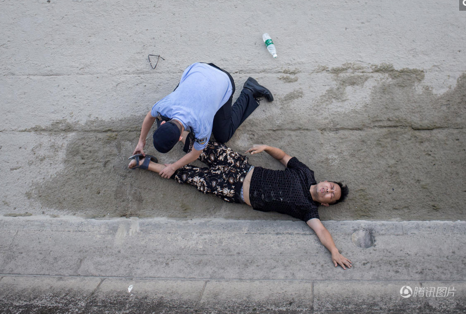 　　男子示意要喝水，民警拿起旁边的矿泉水给他喂水，让他慢慢喝，男子示意腰痛。