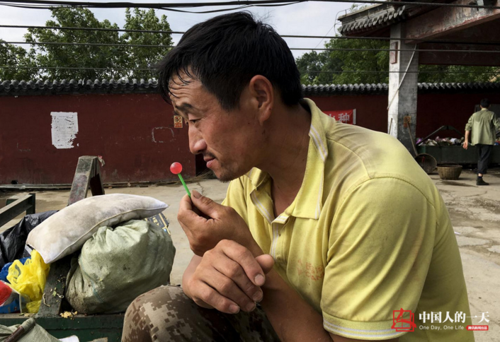 　　一位挑山工吃棒棒糖解乏。炎热的夏天，嘴里来点甜味，或许能冲淡生活的苦味。