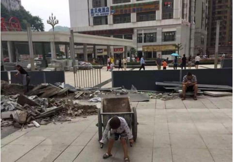 　　图为小男孩在工地推小车现场。