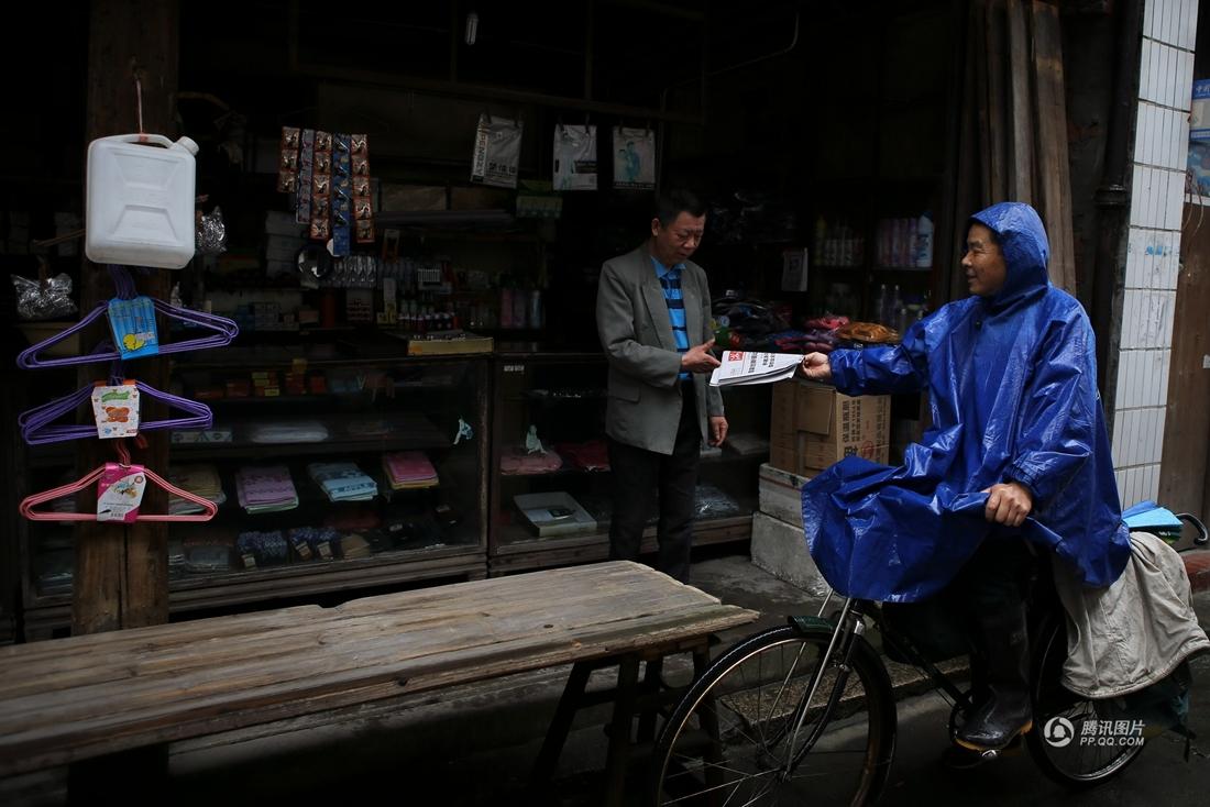 下雨天，老街上游客并不多，店主拿着沈文元投递的报纸，几位老乌镇也唠唠家常。