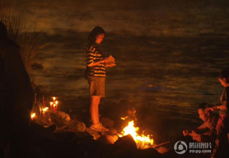 　　四川雅安青衣江边，千人烧纸祭奠逝去的亲人，星星点点的火光连成一片红色。