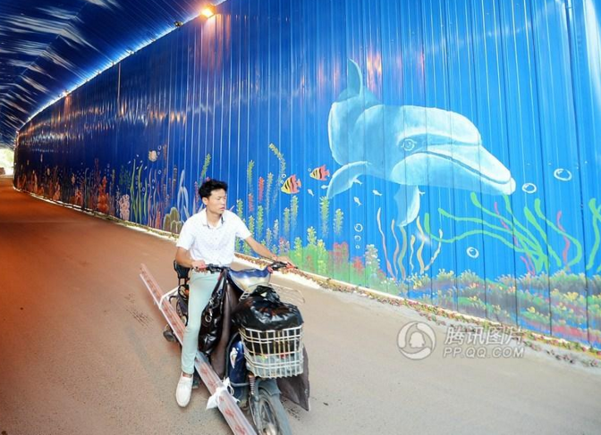 　　近日，济南一小区施工中的临时通道网络走红，几十米长的临时通道变身“海底隧道”，置身其中如入梦幻世界，引发关注。这是济南市文化东路一小区，因周边工地施工，进出通道搭建起长约200米、高约6米的蓝色围挡，顶部用白漆喷绘成云朵，两侧彩绘上海豚、鲸鱼、海龟、热带鱼、水草等图案。