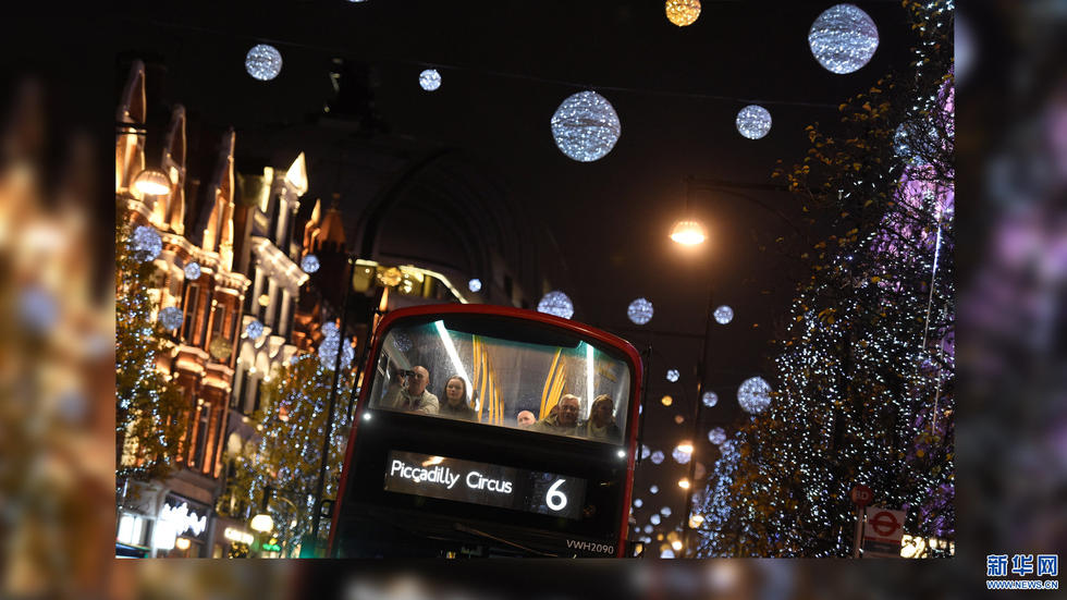 12月9日，在英国伦敦，公交车行驶在装饰着圣诞彩灯的牛津街上。