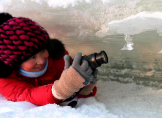 黑龙江江面现“冰洞”女游客洞中拍照